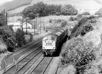 A class 40 hauled southbound train passing Auldgirth signal box in October 1970. Auldgirth station (closed 1952) stands in the left background alongside the bridge.<br><br>[John Furnevel 18/10/1970]