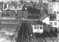 A 1975 view from the footbridge at Gateshead East station across Robert Stephenson's double deck High Level Bridge. The lower level carries a road and a pedestrian walkway, which can be clearly seen bottom left - including the section vaulted by Michael Caine while making his escape in the 1971 film <I>'Get Carter'</I>. The Castle Keep stands in the right background. [See image 18934]<br><br>[John Furnevel 20/10/1975]