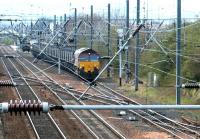 A coal train has just turned off the ECML after passing through Prestonpans station in April 2002 and is currently standing on the line into Cockenzie power station (the up platform at Prestonpans can be seen in the left background). The train is currently held at signals awaiting clearance to enter the yard.  <br><br>[John Furnevel 12/04/2002]