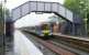 Wet plaform scene at Falkirk High looking west in 2005 as a train arrives from Glasgow Queen Street.<br><br>[John Furnevel 25/05/2005]