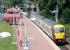 Balloch old and new in July 2005. The site of the old station, which required a level crossing over the A811 road, can be seen in the centre background. The current station, with an Airdrie train at the platform, came into operation in April 1988. <br><br>[John Furnevel 28/07/2005]