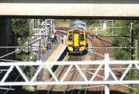 The 12.17 train to Waverley waits alongside the platform at Newcraighall station on 20 August 2012. Long lens view from Whitehill Road at the north end of Millerhill Yard, looking under the bridge carrying the A1.<br><br>[John Furnevel 20/08/2012]