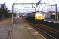 311102 drawing into Port Glasgow with a service for Glasgow Central, sometime in 1980. Note the old footbridge still in place to the left. This provided access to the station and crossed the bay platform once used by Wemyss Bay trains. [See image 22579]<br><br>[Graham Morgan Collection //1980]