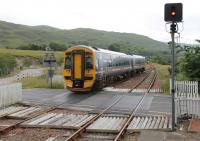 Inverness based 158715 crosses the A890 main road as it leaves Strathcarron heading for Kyle of Lochalsh. From here the road runs alongside the railway almost all the way to Stromeferry with a number of vantage points. <br><br>[Mark Bartlett 11/07/2012]