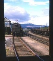 Photograph taken from Invergordon goods shed in summer 1973. A southbound freight has collected sundries vans and is preparing to head off to Inverness.<br><br>[David Spaven //1973]