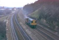 08659 and a brakevan head east into Horbury cutting in March 1983. This was probably trip working 9K47 from Healey Mills Yard (see lighting towers in background) to collect wagons from Wakefield Wagon Repair Depot. 08659 continued in service for another eight years before withdrawal from Healey Mills in 1991 and was cut up in Margam four years later. This stretch of line was reduced from four tracks to two in 1991. <br><br>[Mark Bartlett 24/03/1983]