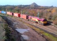 A container train takes the link from the Birmingham line to the WCML  at Nuneaton on 14 November. The spoil heap in the background is the waste tip from (the formerly rail-served) Judkins quarry. It is now adjacent to the local 'recycling facility' and can be seen from miles around. Meanwhile, the catenary seen here will eventually be extended to Whitacre Junction and Birmingham.<br><br>[Ken Strachan 14/11/2012]