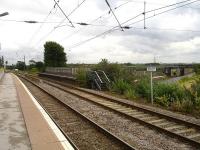 Looking north east along the high level platform at Lichfield in July 2012 with the shortened disused platform on the right. The signal box controlling the north to east spur stands in the left background.  The lower level West Coast main line can be seen centre right approaching from the Tamworth direction.<br><br>[David Pesterfield 31/07/2012]