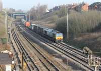 Bright spring sunshine as DRS 66423 takes a long container train along the Up Fast line at Farington Curve Junction in March 2012.<br><br>[Mark Bartlett 22/03/2012]