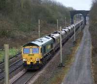 Freightliner 66560 leads a rake of empty coal wagons from Fiddlers Ferry Power Station to Hunterston between Coppull and Balshaw Lane Junction near to the village of Charnock Richard on 3 January 2013. Although Charnock Richard has never had a railway station the name will be familiar to many through its association with the motorway service area on the M6 just to the west.<br><br>[John McIntyre 03/01/2013]