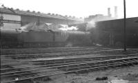 A haze hangs over the busy shed yard at Heaton, thought to be in 1960. In the centre of the photograph stands one of the shed's allocation of V2 2-6-2 locomotives, no 60932.<br><br>[K A Gray //1960]