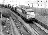 A Class 56 brings coal empties round the Edinburgh 'sub' in 1982. The train is about to pass eastbound through the remains of Morningside Road station with building work underway in the background on the site of the former goods yard.<br><br>[John Furnevel 11/11/1982]