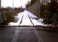 The mud, grass, and snow on the rails tell a sad story of non-use in this view looking ESE towards Coventry City's Ricoh Stadium, just visible on the skyline [see image 35643]. The Stadium station is now due to be built in 2014. A second pair of rails is set in the tarmac to the left of this crossing, at the evocative-sounding junction of Winding House Lane and Wheelwrights Lane.<br><br>[Ken Strachan 26/01/2013]