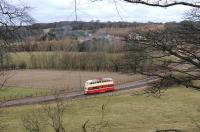 On-loan Blackpool 'Balloon' car 703, disguised as Sunderland tram 101, passes Pockerly Manor, Beamish, on its way to the authentically smoking Town in the background on 2 April 2013. [See image 42616]  <br><br>[Brian Taylor 02/04/2013]