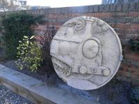 This roundel of a J36 - appropriately the last working class of steam <br>
locomotive in Scottish mainline service, and based in Fife - by local <br>
sculptor Kenny Munro now decorates the station car-park which has been <br>
landscaped by the Kinghorn Station Studios and Gallery. [See image 23043]<br><br>[John Yellowlees 09/04/2013]