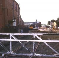 The west side of Bridlington station in 1988 looking towards Hull. The main station building is on the left and the gate gave access to a large goods yard (now a car park and supermarket site) behind the camera. The Scarborough bound DMU is at platform 4, with demolition work in progress around platforms 1 - 3 and the former Station Road entrance. Housing now occupies the area beyond the wooden fence. [See image 23828]<br><br>[Ian Dinmore /09/1988]