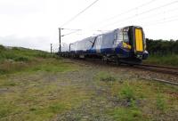 An Ayr-bound 380 unit passing the site of Lochgreen Junction at the south end of the Troon Loop on 29 June 2013. Photographed from the track-bed of the original direct line. [See image 28035] <br><br>[Colin Miller 29/06/2013]