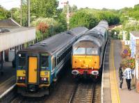 DRS 47802 brings a Great Yarmouth - Norwich train through Acle on 21 June 2011, passing a pair of class 153s waiting at the eastbound platform. DRS 47712 is on the rear of the train. [See image 43341]<br><br>[Ian Dinmore 21/06/2011]