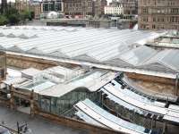 A touch of glass. View over Waverley towards Princes Street on 7 July 2013. Dominating the scene is a section of the recently reglazed station roof. In the foreground is the transformed Market Street entrance with work continuing on new access and replacement canopies for 'sub' platforms 8 & 9. In the background, immediately to the left of the Balmoral Hotel, is part of the glass roof covering Waverley Steps, with passenger lifts now operating alongside. <br><br>[John Furnevel 07/07/2013]
