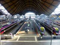 A view north from the footbridge at Southern Cross on 21 May 2013 showing the 'undulating roof', designed by British architect Sir Nicholas Grimshaw - winner of a RIBA prize. The number of VLocity dmus grows apace as they displace loco-hauled services. There is currently political pressure to revert to the former name of 'Spencer Street Station'.<br><br>[Colin Miller 21/05/2013]