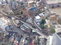 View over Borough Market Junction on 20 July with trains on the Charing Cross / Blackfriars route (left) and the cross-Thames lines from Cannon Street. The new east-west viaduct seen under construction will enable quadrupling here, with the southern pair of lines handling trains to and from Charing Cross and the northern pair providing Thameslink trains with a dedicated route to Blackfriars - essential in providing the planned 24tph peak service on the route. London Bridge station is just off picture bottom right.<br><br>[John Thorn 20/07/2013]