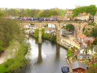 Looking east along the River Nidd at Knaresborough with a Northern DMU on the viaduct. The unique Knaresborough signal box [see image 23671] can be seen on the right of the picture. <br><br>[Ian Dinmore //]
