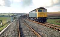 The severed link at Crediton in 1985. View west showing the disconnected double track to Newton St Cyres. The class 47 is hauling a Meldon Quarry to Exeter Riverside ballast train.<br><br>[Ian Dinmore //1985]