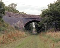This substantial looking overbridge at Hassendeanburn Farm, just over a mile on the Hawick side of Hassendean station, only carries a minor road over the former Waverley Route. The cutting on the down side of the bridge has been partially infilled to allow vehicles access along the trackbed from the farm, which is adjacent on the left. <br>
<br><br>[Bill Jamieson 09/08/2013]