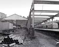 The original Haymarket train shed in the course of dismantling in late 1982 as a Waverley bound DMU waits at platform 1. Much of the structure would reappear as part of the SRPS station at Boness, while the trackbed on the right would also reappear 25 years later as platform 0 [see image 17459].<br><br>[Bill Roberton //1982]