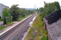 The fire damaged station building at Crookston looking west in 1990 as the line to Paisley Canal is prepared for re-opening. A stack of lifted track stands in the distance.<br><br>[Ewan Crawford //1990]