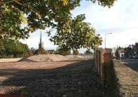 The station site at Dalkeith, now cleared and ready for construction of the new supermarket. View east towards the town centre on 5 October 2013. The A6094 Eskbank Road is on the right and the 167 ft spire of the former West Church on Old Edinburgh Road stands in the left background. [See image 37347] <br><br>[John Furnevel 05/10/2013]