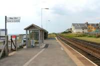 Looking north towards Sellafield on a summer evening at Seascale. A <I>Harrington Hump</I> can be seen at the far end of the platform from where it will afford level access to the front door of trains. Part of the huge nuclear complex is just visible in the cutting beyond the station.<br><br>[Mark Bartlett 27/07/2013]