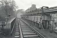 Scene on the Kirkcaldy harbour branch in late 1984, shortly after closure. Looking back over the Port Brae bridge with the line veering to the left past a rail-served transfer shed.<br><br>[Bill Roberton //1984]