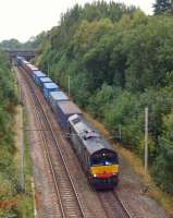 DRS 66427 heads a southbound container train past the site of Boar's Head Junction on 2 October 2013. The junction was to the right of the locomotive and ran via Red Rock to join the Preston - Bolton line at Adlington. The line was lifted in the early 1970s.<br><br>[John McIntyre 02/10/2013]