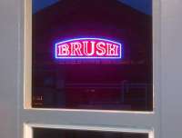 The famous neon sign, framed by the steelwork of the recently erected Loughborough station footbridge. View east in October 2013.<br><br>[Ken Strachan 25/10/2013]