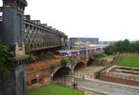 View south west with the viaduct that once carried lines out of Manchester Central station on the left as a Northern serviceheading into the citypasses below on the line from Ordsall Junction to Deansgate.<br><br>[John McIntyre 04/10/2013]