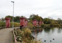 Just beyond the end of Acccington's Bury line platforms the 1:37 Baxenden bank started on a bridge over a mill reservoir. The trackbed greenway now runs between the columns of that demolished bridge as a feature of what is now this urban park. <br><br>[Mark Bartlett 15/11/2013]