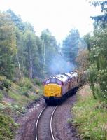 A pair of EWS class 37s with a southbound ballast train start to accelerate away from a stop at Aviemore in September 2004. The leading locomotive is 37406.<br><br>[John Furnevel 14/09/2004]
