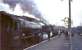 Crab 42737 stands quietly at Beattock station on 29 March 1964, waiting to return to Glasgow Central with <I>Scottish Rambler no 3</I>. The fuss in the background centres around Beattock shed's BR Standard class 4 no 80001, which is in the process of banking out the down <I>Royal Scot</I>.<br><br>[John Robin 29/03/1964]