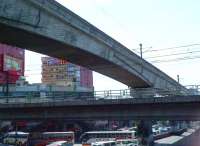 The new Light Rail Transit Line 3 is seen between Cubao and Kamoning, striding purposefully over Line 2 between Araneta Center and Betty Go-Belmonte (a station, not a person..) The Jollibee restaurant (lower left) is the local equivalent of Macdonald's.<br><br>[Ken Strachan 16/01/2014]