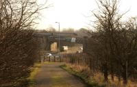 A class 156 DMU crosses the <I>Cutty Sark</I> bridge over the A8 on its way to Baillieston, during the morning of 30th January 2014. This viewpoint on Bredisholm Road will disappear during the planned Baillieston - Newhouse M8 extension works. [See image 46140]<br><br>[Colin McDonald 30/01/2014]