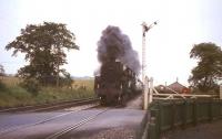 The 2pm Dundee - Glasgow Buchanan Street about to run over Lenziemill level crossing on 3 August 1965. Locomotive in charge is Standard class 5 4-6-0 no 73057.<br><br>[G W Robin 03/08/1965]