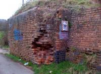 Here is an abutment that is so decayed, it is positively artistic. It stands (just) adjacent to a farm road in the Ansley Common area of Nuneaton. Even the notice about trapping dogs (?) has been vandalized.<br><br>[Ken Strachan 21/03/2014]