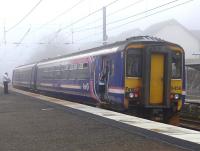 156456 calls at Kirknewton with a Glasgow Central - Edinburgh service on a foggy 30 March.<br><br>[Bill Roberton 30/03/2014]