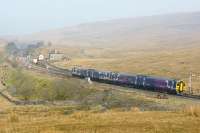 A Northern service from Leeds to Carlisle leaves the single line section from Ribblehead station and approaches Blea Moor signal box on 29 March 2014.<br><br>[John McIntyre 29/03/2014]