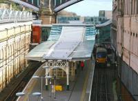 The view east from Waverley Bridge showing the new canopy over the 'sub' platforms. The structure is echoed in the refurbished Market Street station entrance as well as the Edinburgh Council HQ in the background. Hiding in the shadows alongside platform 8 is the 12.07 service to Milngavie. Note the attractive varitone brown cladding. [See image 17536]<br><br>[John Furnevel 11/04/2014]
