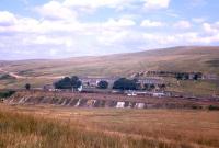 Panorama showing Riccarton Junction in September 1963 from Bell Hill, with an A3-hauled freight standing at the down platform. The newly-constructed Forestry Commission access road which ended Riccarton's total rail dependence is visible to the north, and the extensive ash filling required to form the railway yard west of the station is also evident.<br><br>[Frank Spaven Collection (Courtesy David Spaven) /09/1963]