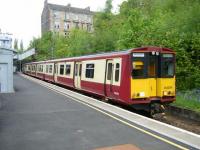 A southbound train, heading for Neilston, calls at Mount Florida on 15 May 2014, with the tenements of McLennan Street standing in the background. <br><br>[Veronica Clibbery 15/05/2014]