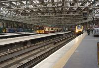At around 1830 on a weekday evening Glasgow Central looks remarkably quiet under the big roof with only a Class 156, a 313, a Voyager and, hiding on the right, a Pendolino.<br><br>[John McIntyre 07/05/2014]