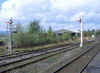 These shunting signals on the down side at Hellifield in April 2014 provide a contrast in styles - no prizes for guessing which one dates from the 21st century! Beyond is the bracket signal carrying the down starter and exit signal from the down loop.<br><br>[Bill Jamieson 24/04/2014]